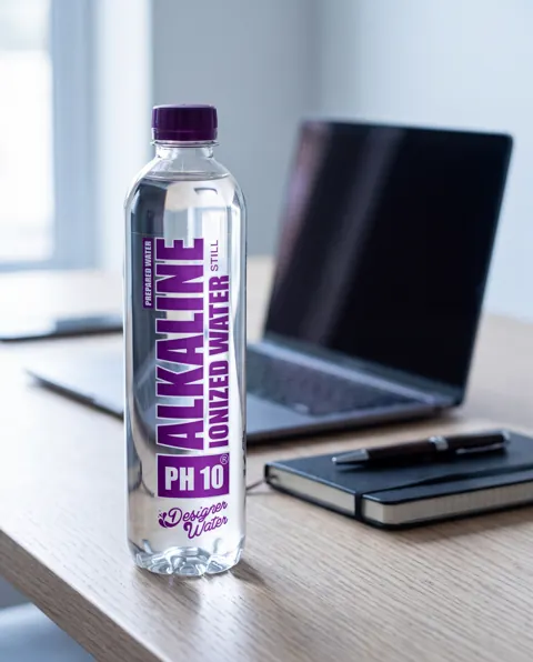 Designer Water pH10 beside a laptop on a work desk