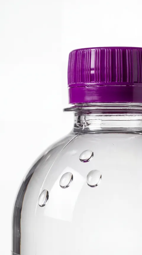 A close-up of the distinctive Designer Water purple cap and clear bottle